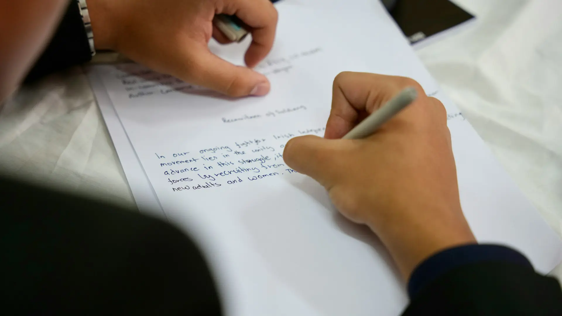 A person writing on a piece of paper